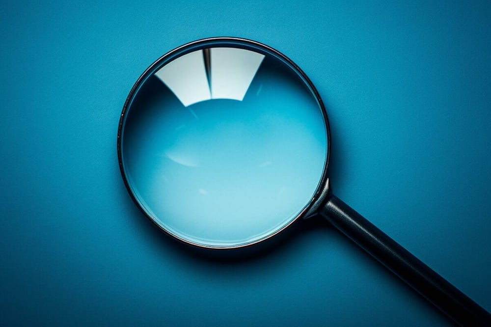 Eine Suchlupe vor blauem Hintergrund